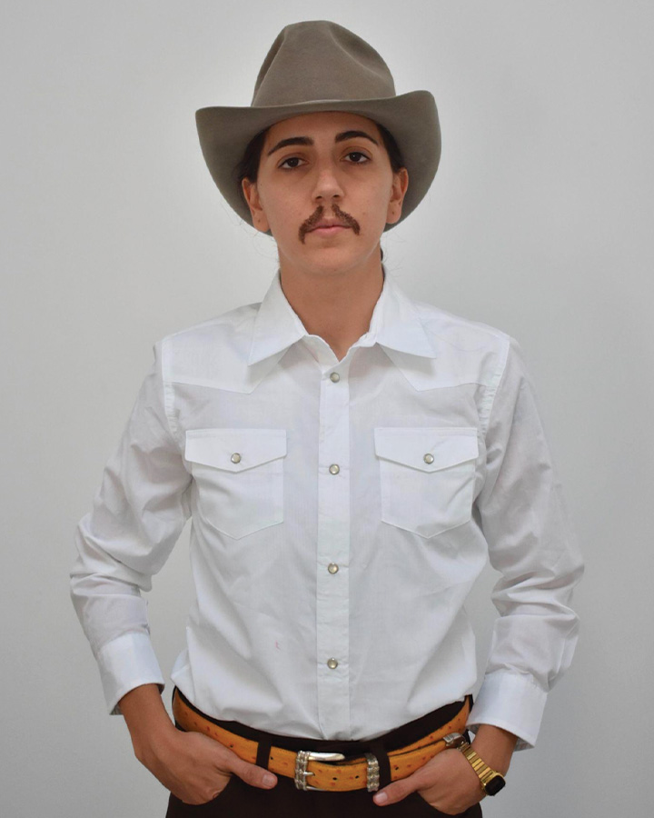 a person standing up straight wearing a white button down and cowboy hat.